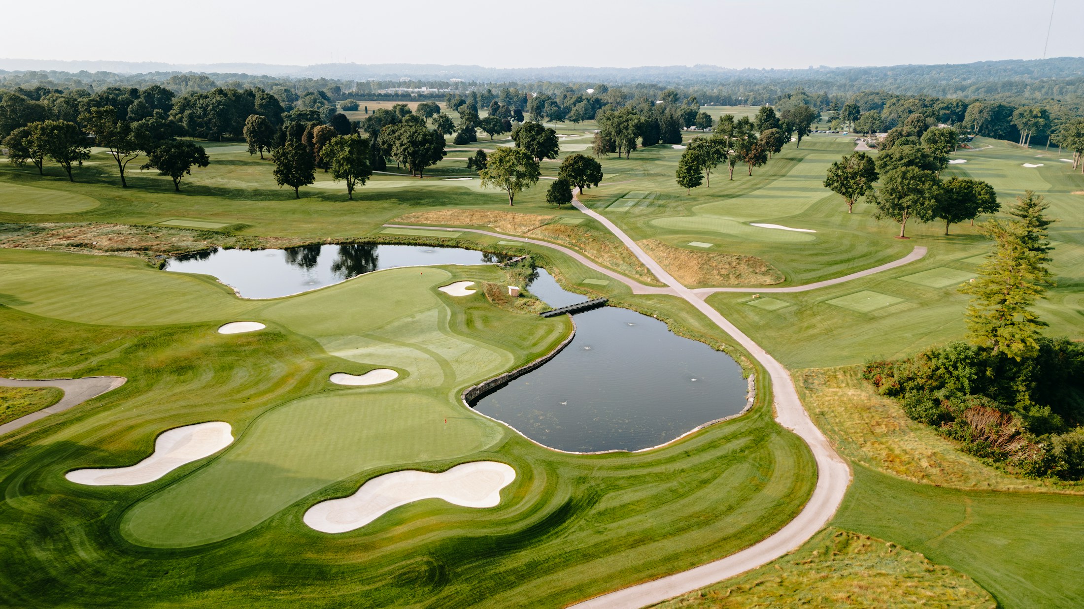 Aerial view of a course with ponds and white bunkers